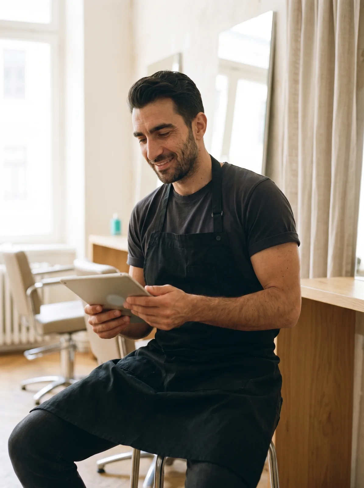 Il titolare del salone che legge sul tablet i numeri del mese